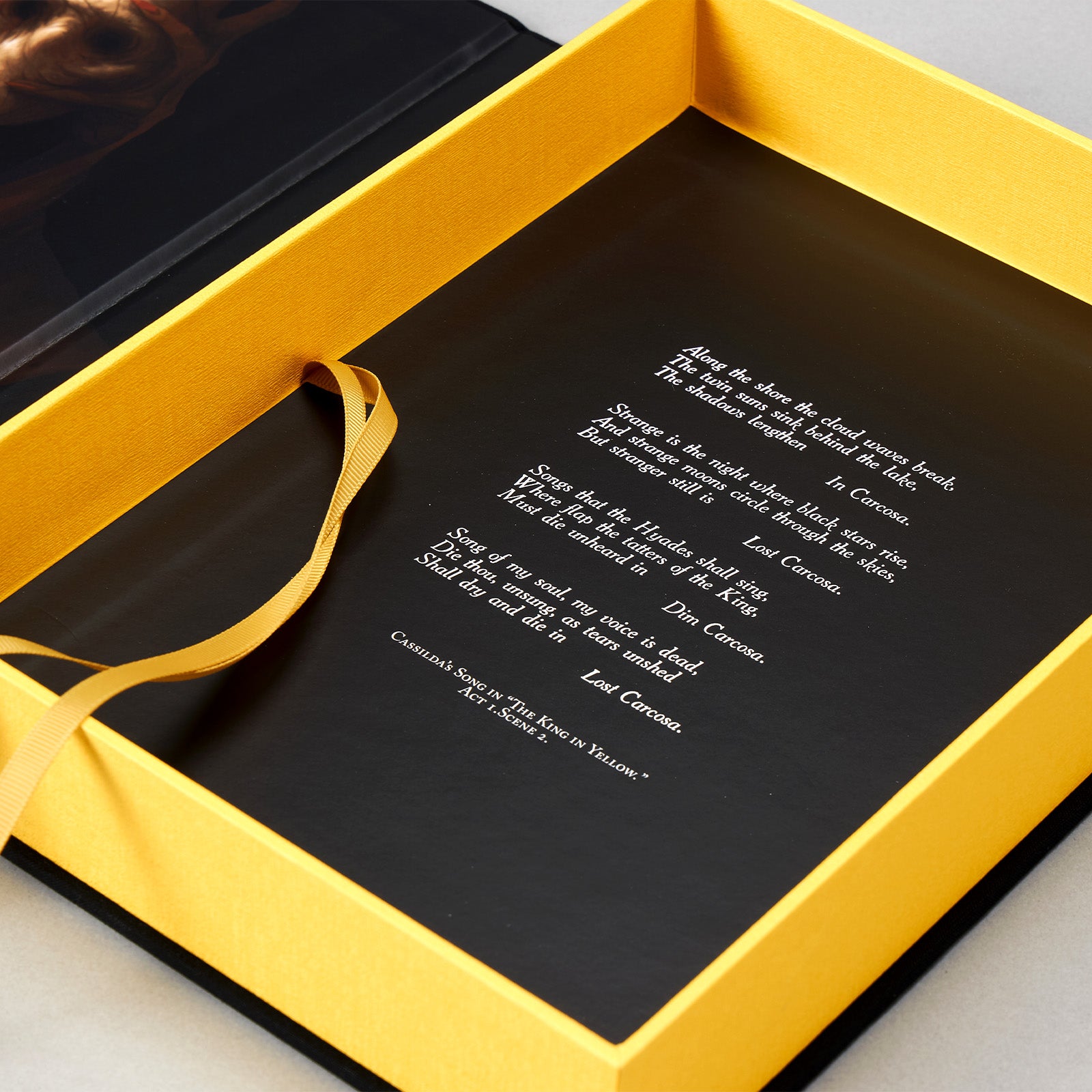 Interior of the Artefact Edition clamshell case — Cassilda's Song in white on black, with the Stranger figure by Arturo Velasco below.