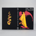 The King in Yellow Artefact Edition shown front and spine on a gray background — silver-foil title and red-and-gold cover figure.